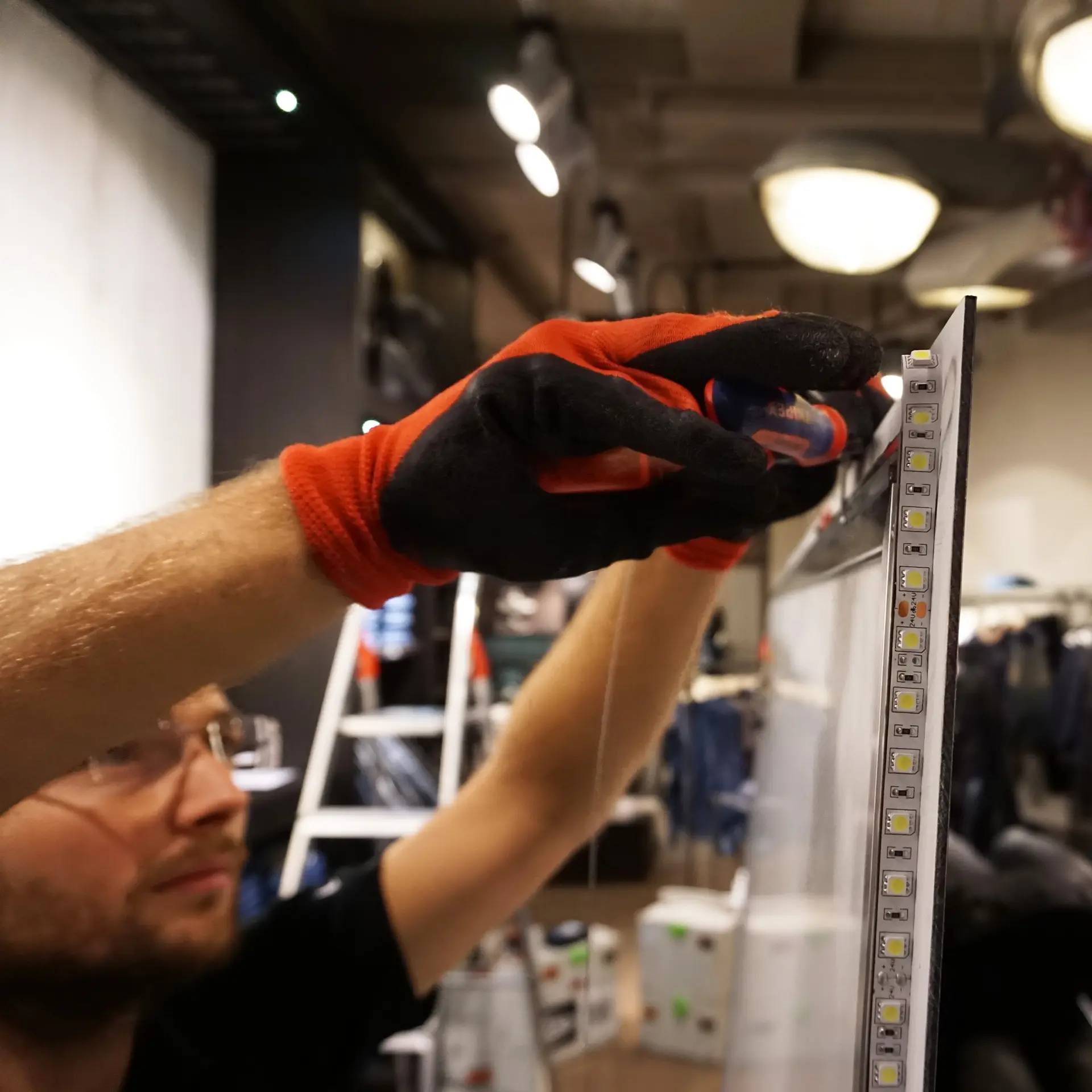 Montageservice von AR Display, Mann montiert Schild für Ladeneinrichtung